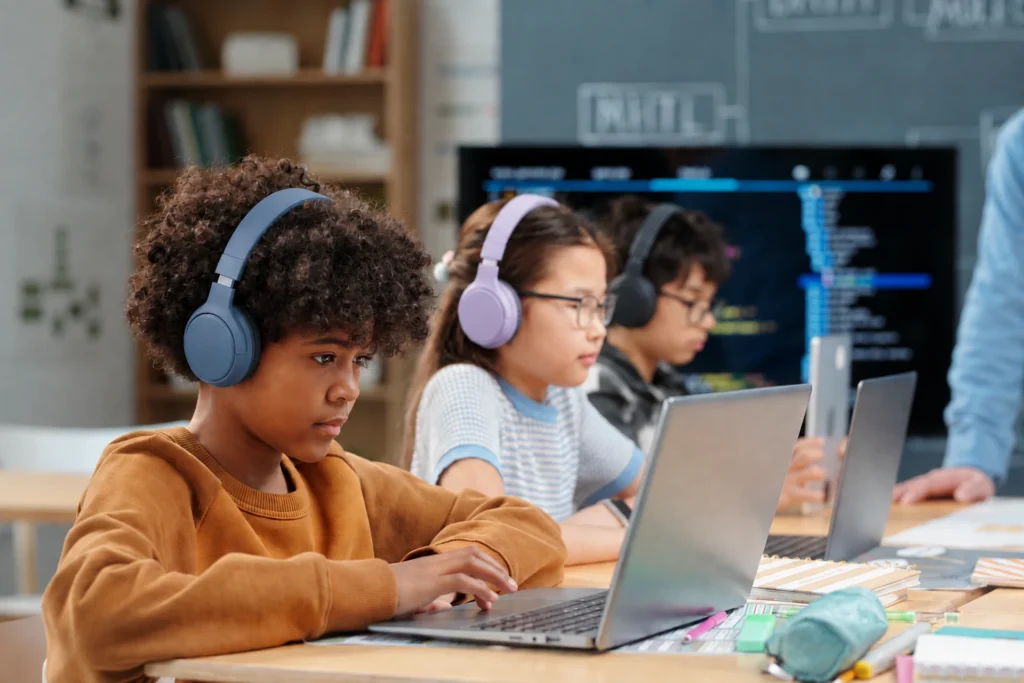 three students working at their laptops