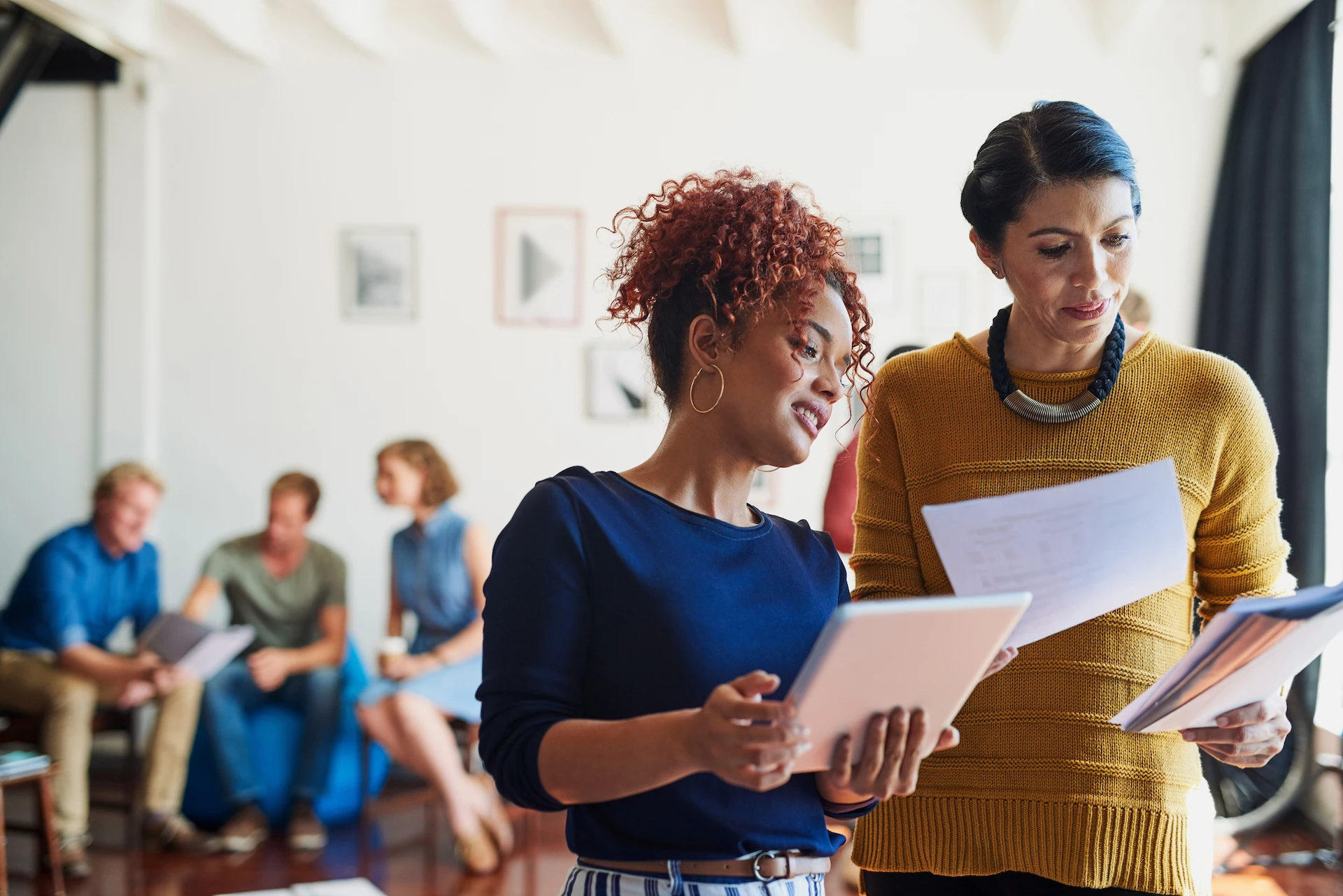 A group of teachers in a room looking at and comparing reports and notes